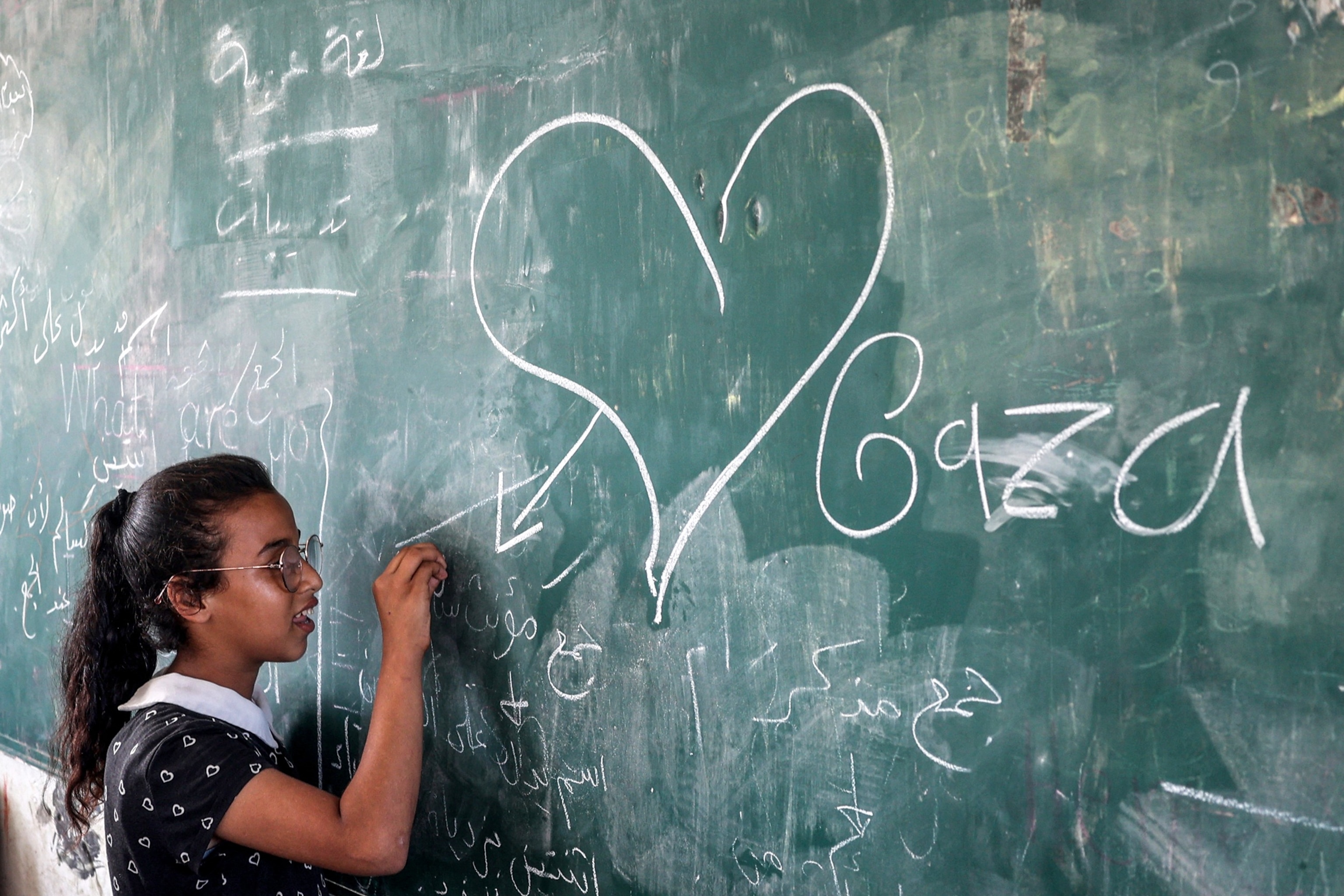PHOTO: A girl draws on a blackboard at a school sheltering people displaced by conflict run by the UNRWA in Deir el-Balah in the central Gaza Strip on Sept. 9, 2024, amid the ongoing war in the Palestinian territory between Israel and Hamas.
